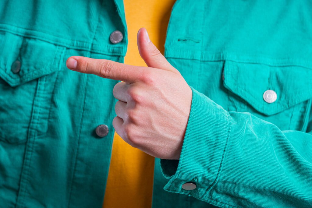 Main d’une personne pointant vers la droite, symbolisant l’orientation vers une solution ou une direction claire.