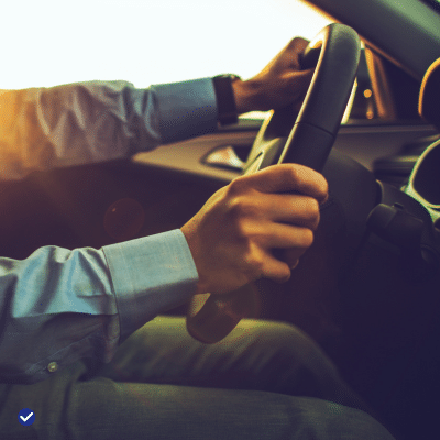 Conducteur au volant d'une voiture d'occasion achetée chez un vendeur professionnel