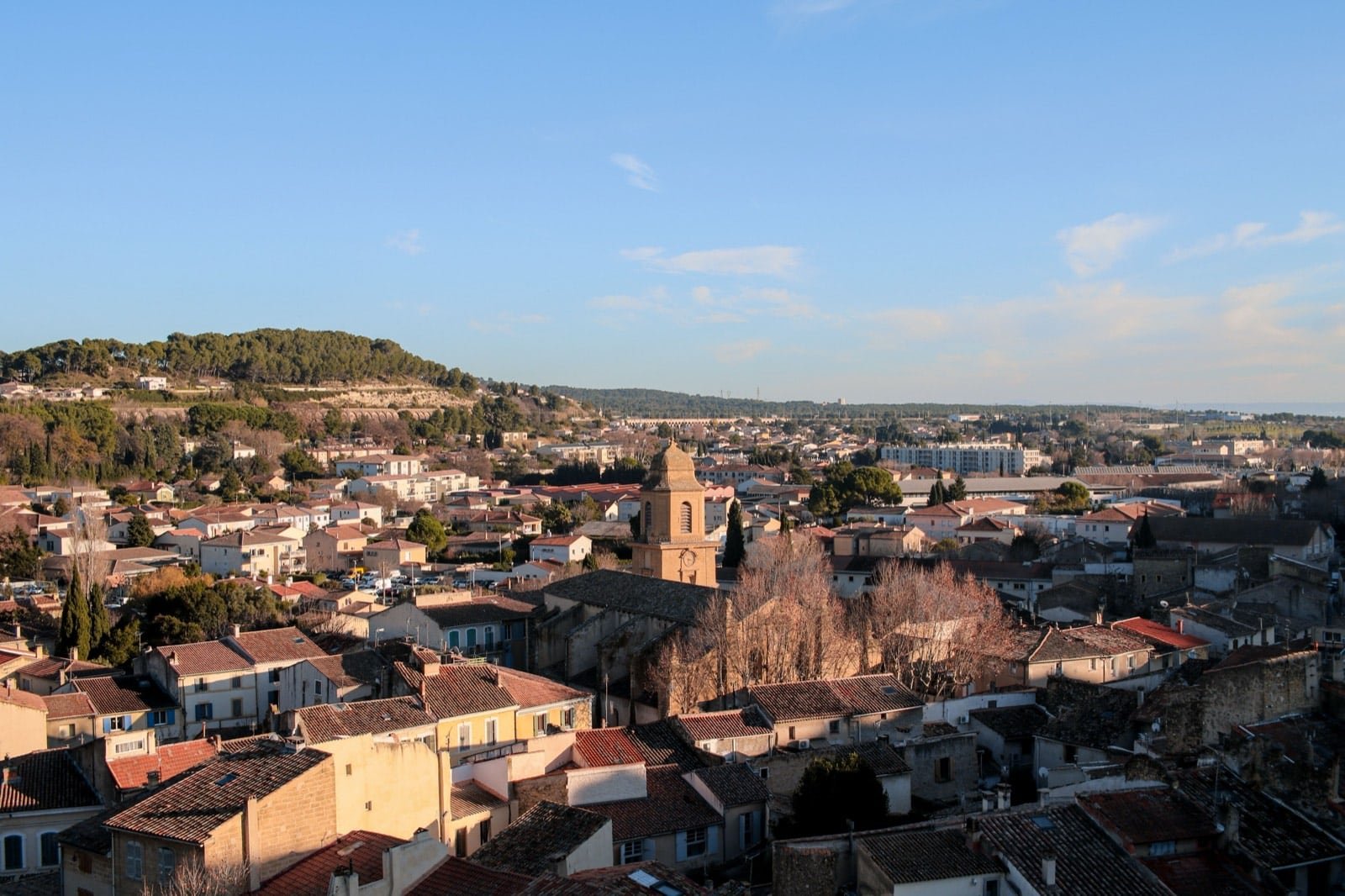 Toits de tuiles et clocher d’Aix-en-Provence sous un ciel bleu, zone d’intervention de l’expert automobile dans les Bouches-du-Rhône